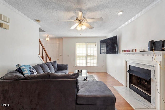 4108 Lazyriver Ln, Durham, NC 27712 - living area with a fireplace, a textured ceiling, stairway, wood finished floors, and crown molding