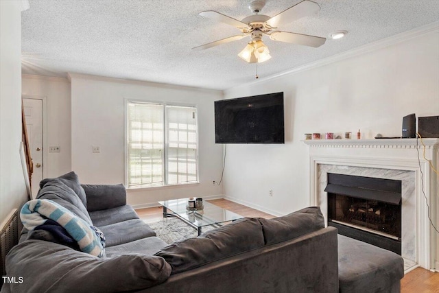 4108 Lazyriver Ln, Durham, NC 27712 - living room featuring a textured ceiling, light wood-style flooring, ceiling fan, ornamental molding, and a high end fireplace