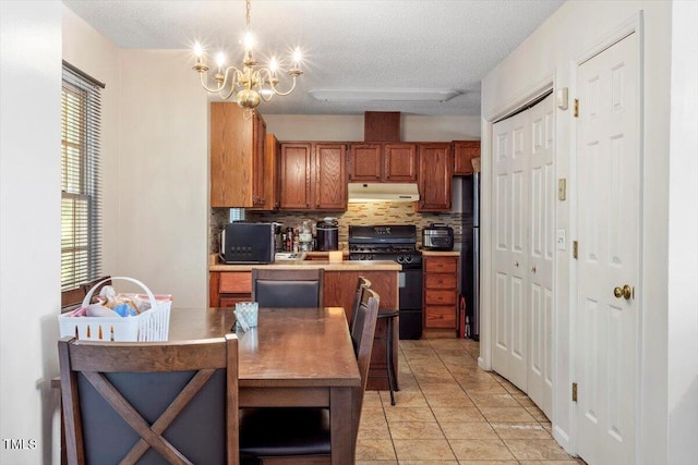 4108 Lazyriver Ln, Durham, NC 27712 - kitchen with black gas stove, under cabinet range hood, dishwasher, brown cabinetry, and a chandelier