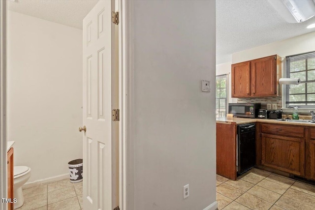 4108 Lazyriver Ln, Durham, NC 27712 - kitchen featuring black appliances, light countertops, light tile patterned floors, a sink, and a textured ceiling