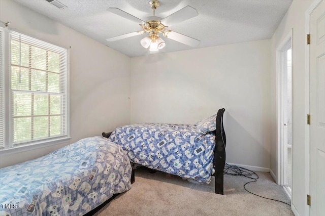 4108 Lazyriver Ln, Durham, NC 27712 - carpeted bedroom featuring multiple windows, a textured ceiling, ceiling fan, and baseboards