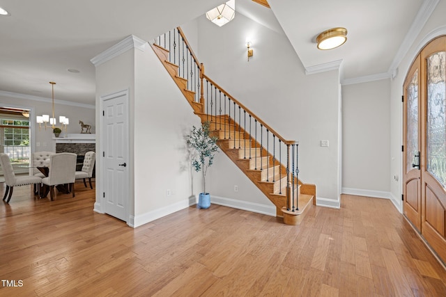 4913 Great Meadows Ct, Raleigh, NC 27609 - entryway with stairway, light wood finished floors, baseboards, a chandelier, and crown molding