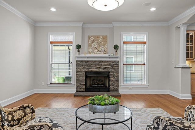 4913 Great Meadows Ct, Raleigh, NC 27609 - living room with ornate columns, wood finished floors, plenty of natural light, a stone fireplace, and crown molding