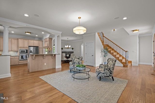 4913 Great Meadows Ct, Raleigh, NC 27609 - living area with decorative columns, stairs, light wood-style floors, crown molding, and recessed lighting