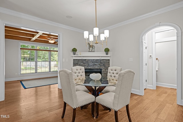 4913 Great Meadows Ct, Raleigh, NC 27609 - dining space with crown molding, baseboards, light wood-style flooring, a chandelier, and a stone fireplace