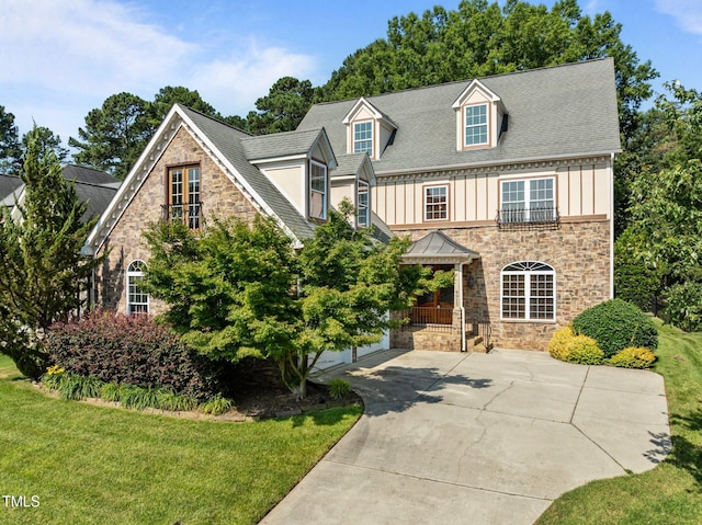 4913 Great Meadows Ct, Raleigh, NC 27609 - view of front facade featuring stone siding, board and batten siding, a front lawn, and a shingled roof