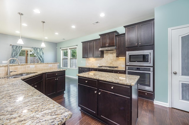 1305 Ivey Grove Ct, Fuquay Varina, NC 27526 - kitchen featuring appliances with stainless steel finishes, tasteful backsplash, dark brown cabinetry, plenty of natural light, and recessed lighting