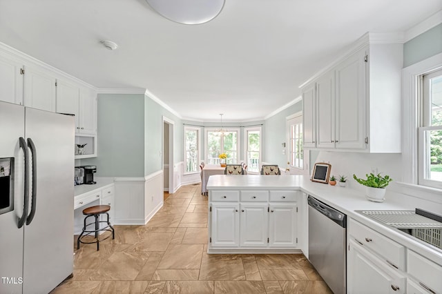 4702 Pleasant Green Rd, Durham, NC 27705 - kitchen with stainless steel appliances, white cabinets, a peninsula, and ornamental molding