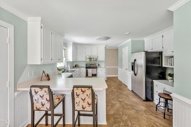 4702 Pleasant Green Rd, Durham, NC 27705 - kitchen featuring appliances with stainless steel finishes, a sink, light countertops, a peninsula, and white cabinets