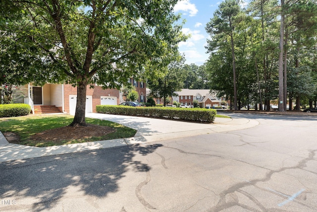 5644 Picnic Rock Ln, Raleigh, NC 27613 - obstructed view of property with brick siding, a garage, and curved driveway