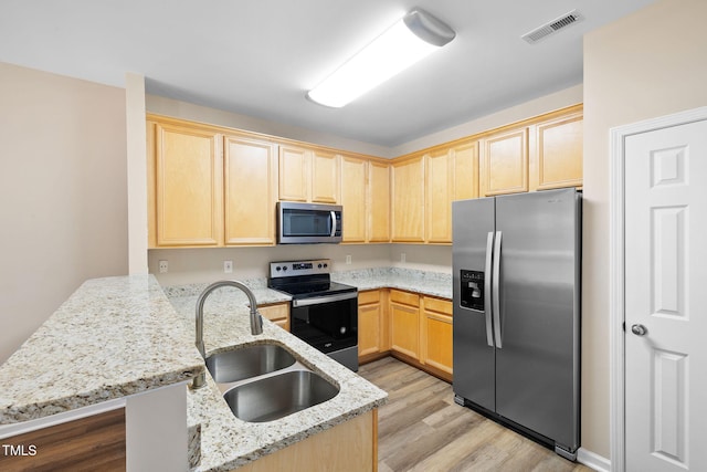 5644 Picnic Rock Ln, Raleigh, NC 27613 - kitchen with stainless steel appliances, light brown cabinetry, a peninsula, light wood finished floors, and light stone counters
