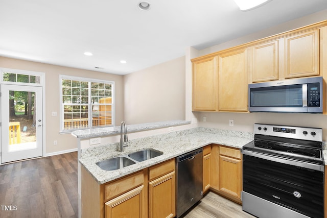 5644 Picnic Rock Ln, Raleigh, NC 27613 - kitchen featuring appliances with stainless steel finishes, a peninsula, light wood-style flooring, light stone countertops, and recessed lighting