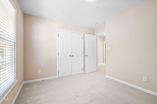 5644 Picnic Rock Ln, Raleigh, NC 27613 - unfurnished bedroom featuring carpet flooring, multiple windows, and a closet