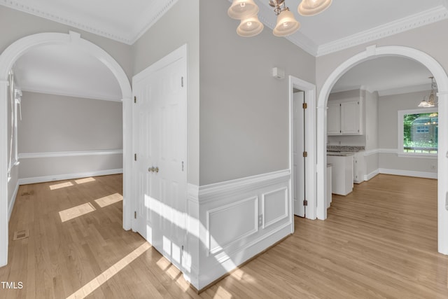 6201 Bayswater Trl, Raleigh, NC 27612 - corridor featuring arched walkways, a chandelier, light wood-style floors, and crown molding