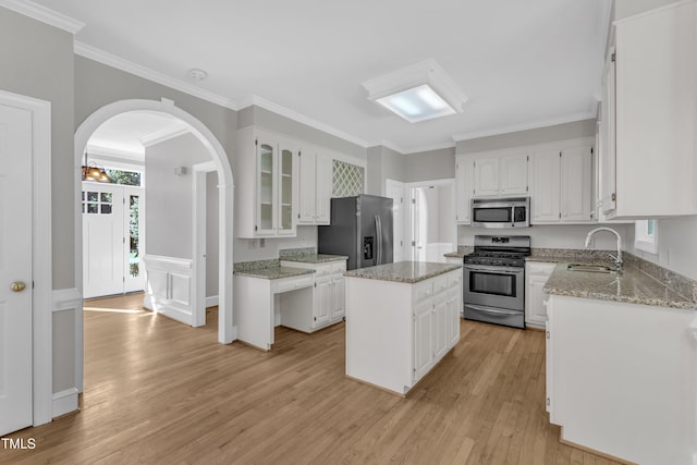 6201 Bayswater Trl, Raleigh, NC 27612 - kitchen with stainless steel appliances, a sink, light wood-style floors, white cabinetry, and crown molding
