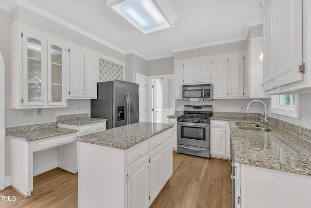 6201 Bayswater Trl, Raleigh, NC 27612 - kitchen with appliances with stainless steel finishes, a sink, light wood-style floors, white cabinets, and light stone counters