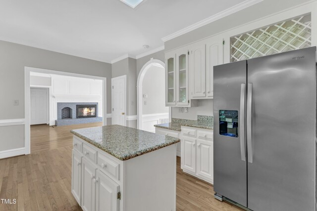 6201 Bayswater Trl, Raleigh, NC 27612 - kitchen with stainless steel refrigerator with ice dispenser, light wood-type flooring, a kitchen island, white cabinetry, and ornamental molding