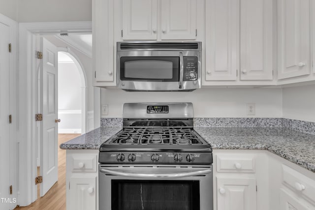 6201 Bayswater Trl, Raleigh, NC 27612 - kitchen featuring stainless steel appliances, white cabinets, light wood-style floors, and light stone counters