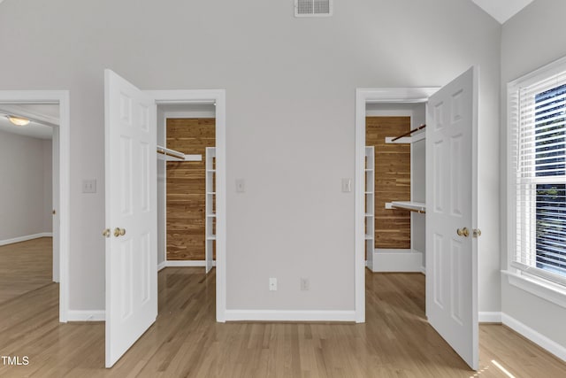 6201 Bayswater Trl, Raleigh, NC 27612 - unfurnished bedroom featuring light wood-type flooring, a spacious closet, baseboards, and multiple windows