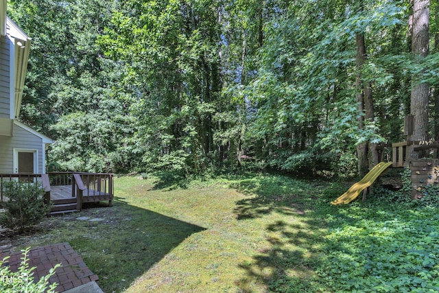 6201 Bayswater Trl, Raleigh, NC 27612 - view of green lawn with a deck, a view of trees, and a playground