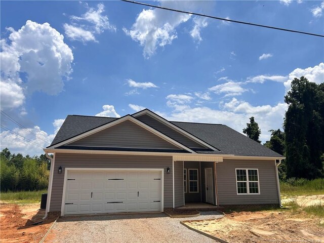 600 Cypress St, Roseboro, NC 28382 - view of front of house with dirt driveway, an attached garage, a shingled roof, and covered porch