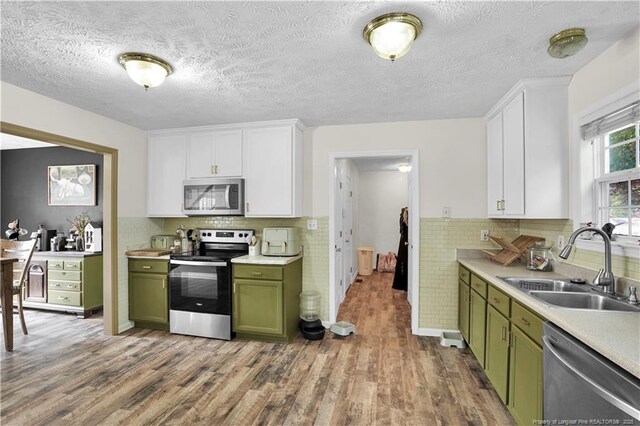 717 Stone Cross Dr, Spring Lake, NC 28390 - kitchen featuring green cabinetry, stainless steel appliances, a sink, wood finished floors, and a textured ceiling
