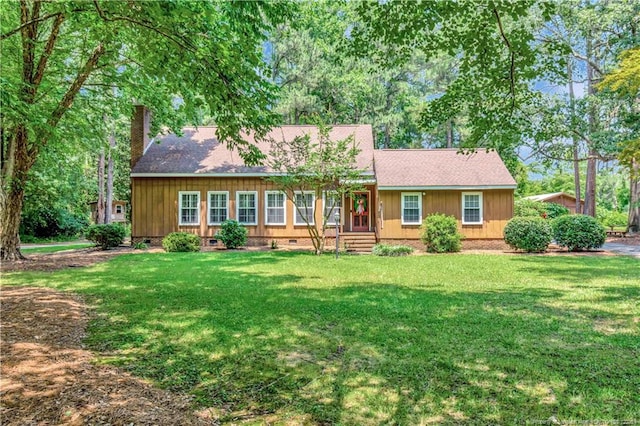 1519 Magnolia Dr, Fairmont, NC 28340 - view of front facade with a chimney, a front yard, crawl space, a shingled roof, and board and batten siding