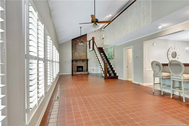 1519 Magnolia Dr, Fairmont, NC 28340 - tiled living room with high vaulted ceiling, ceiling fan, plenty of natural light, a fireplace, and baseboards
