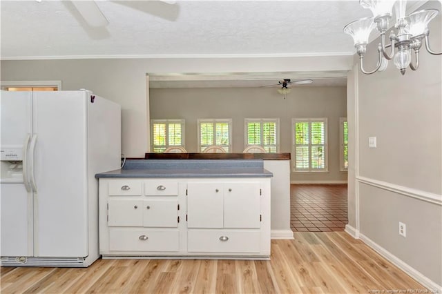 1519 Magnolia Dr, Fairmont, NC 28340 - kitchen featuring white refrigerator with ice dispenser, ceiling fan, white cabinetry, dark countertops, and ornamental molding