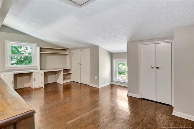 1519 Magnolia Dr, Fairmont, NC 28340 - unfurnished office featuring built in study area, dark wood-style flooring, lofted ceiling, baseboards, and a textured ceiling