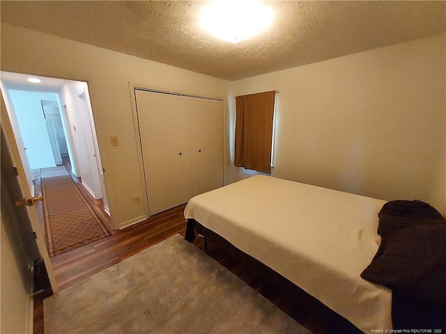 844 Montrose Rd, Raeford, NC 28376 - bedroom with dark wood-style floors, a closet, and a textured ceiling