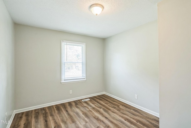 605 Sexton Ave, Zebulon, NC 27597 - spare room with wood finished floors, a textured ceiling, and baseboards