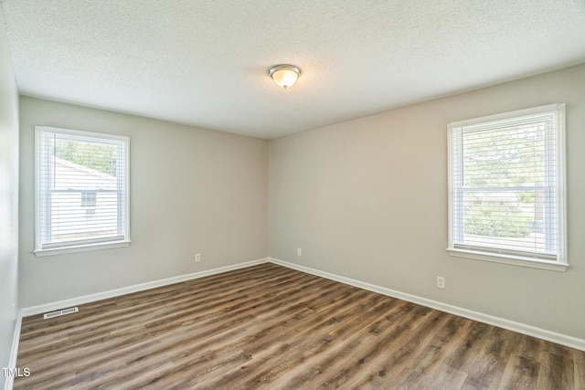 605 Sexton Ave, Zebulon, NC 27597 - unfurnished room with wood finished floors, baseboards, and a textured ceiling