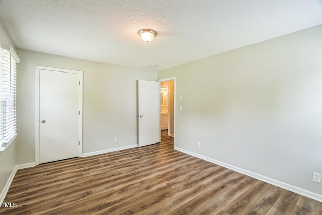 605 Sexton Ave, Zebulon, NC 27597 - unfurnished bedroom with wood finished floors, baseboards, and a textured ceiling