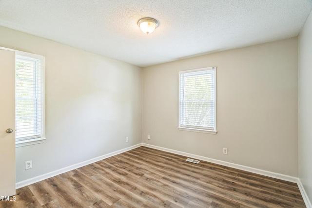 605 Sexton Ave, Zebulon, NC 27597 - spare room featuring healthy amount of natural light, wood finished floors, baseboards, and a textured ceiling