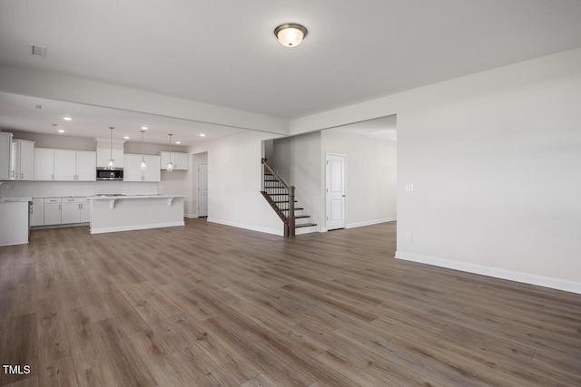 267 Old Fashioned Way, Lillington, NC 27546 - unfurnished living room featuring stairs, recessed lighting, baseboards, and wood finished floors