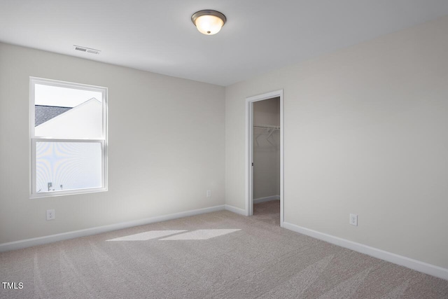 267 Old Fashioned Way, Lillington, NC 27546 - unfurnished bedroom featuring baseboards, light carpet, a walk in closet, and a closet