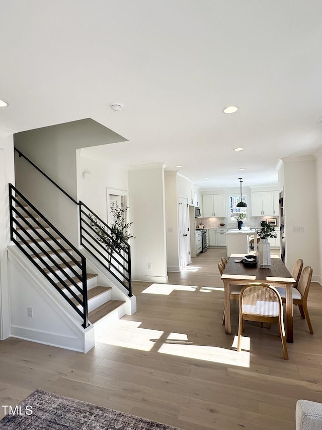974 Double Helix Rd, Apex, NC 27523 - dining room featuring light wood-style flooring, stairway, baseboards, recessed lighting, and ornamental molding