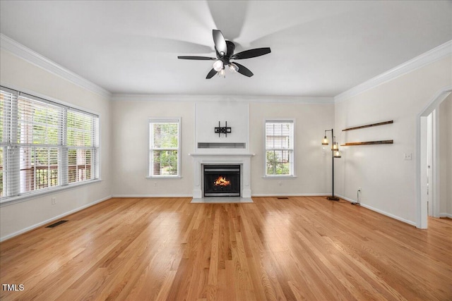 618 Durwood Dr, Raleigh, NC 27603 - unfurnished living room featuring healthy amount of natural light, a fireplace with flush hearth, light wood-style flooring, crown molding, and baseboards