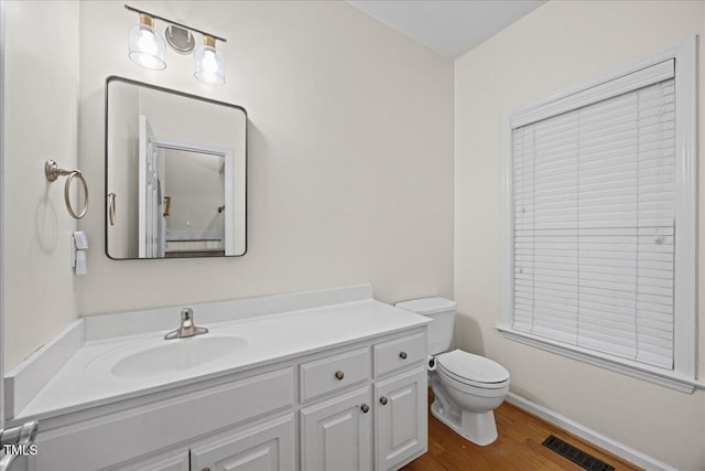 618 Durwood Dr, Raleigh, NC 27603 - bathroom with toilet, vanity, wood finished floors, and baseboards