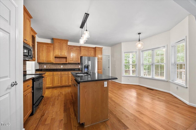 618 Durwood Dr, Raleigh, NC 27603 - kitchen with stainless steel appliances, a sink, backsplash, and light wood-style flooring