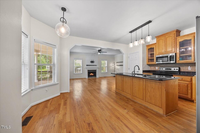 618 Durwood Dr, Raleigh, NC 27603 - kitchen featuring stainless steel appliances, dark countertops, light wood-style flooring, and a ceiling fan