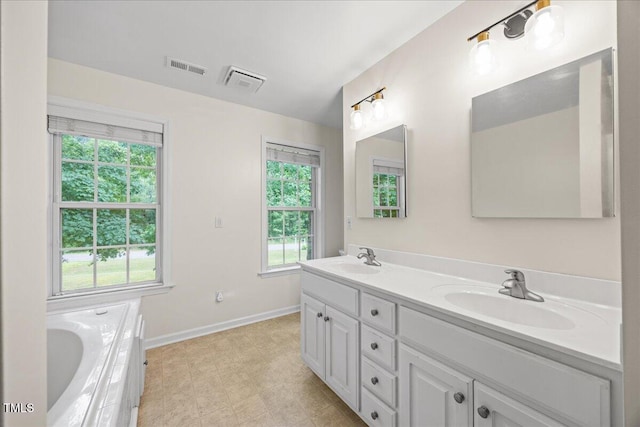 618 Durwood Dr, Raleigh, NC 27603 - bathroom with double vanity, baseboards, and a tub to relax in