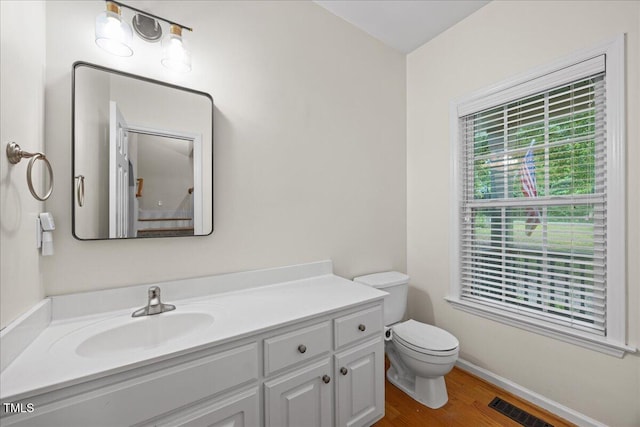 618 Durwood Dr, Raleigh, NC 27603 - half bathroom with toilet, vanity, wood finished floors, and baseboards