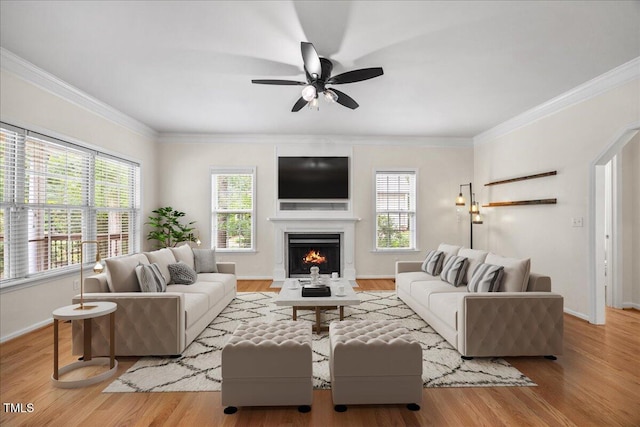 618 Durwood Dr, Raleigh, NC 27603 - living area with healthy amount of natural light, a warm lit fireplace, baseboards, ornamental molding, and wood finished floors
