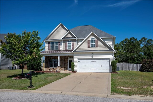 579 Wedgefield Dr, Raeford, NC 28376 - view of front of home with concrete driveway, a porch, stone siding, and an attached garage