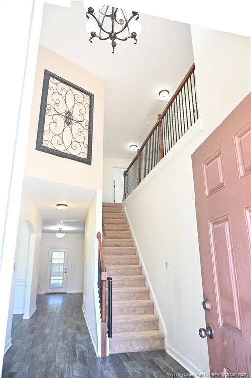 579 Wedgefield Dr, Raeford, NC 28376 - foyer entrance featuring stairs, a chandelier, wood finished floors, baseboards, and a towering ceiling