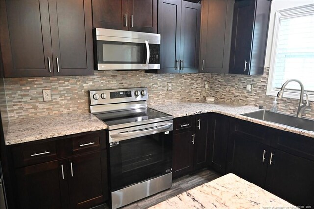 579 Wedgefield Dr, Raeford, NC 28376 - kitchen featuring stainless steel appliances, a sink, wood finished floors, tasteful backsplash, and light stone countertops