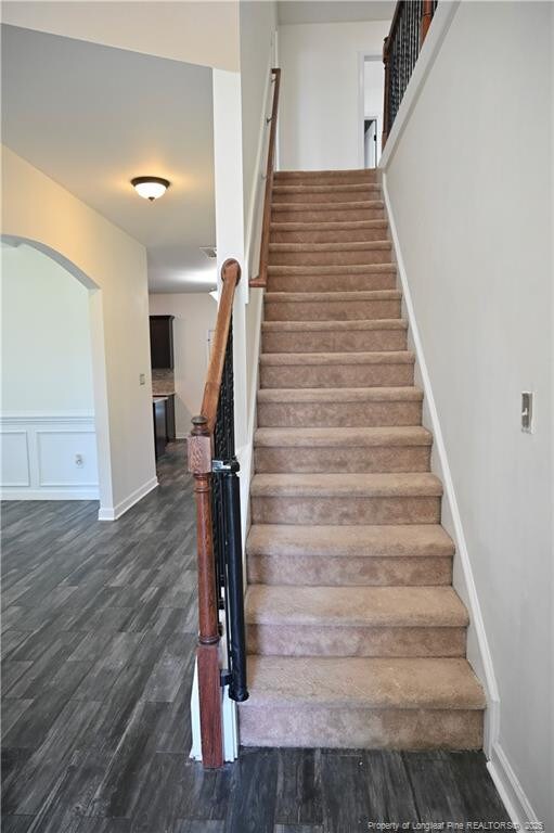 579 Wedgefield Dr, Raeford, NC 28376 - stairway featuring wood finished floors, arched walkways, and baseboards