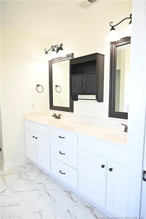 579 Wedgefield Dr, Raeford, NC 28376 - bathroom with double vanity, marble finish floors, and baseboards